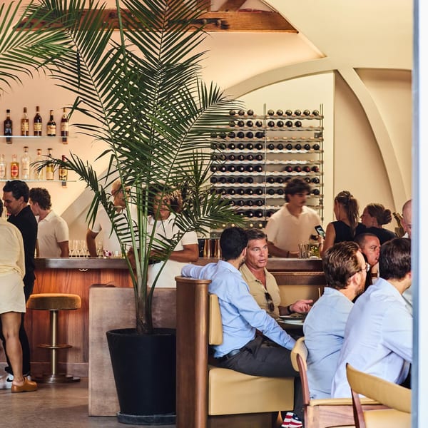 Diners and bar patrons enjoying the lively, modern interior of Edgemar Restaurant + Lounge.
